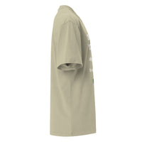 Opposite side view of a Christian oversized T-shirt in muted green. Shows drape and silhouette with partial view of front design.